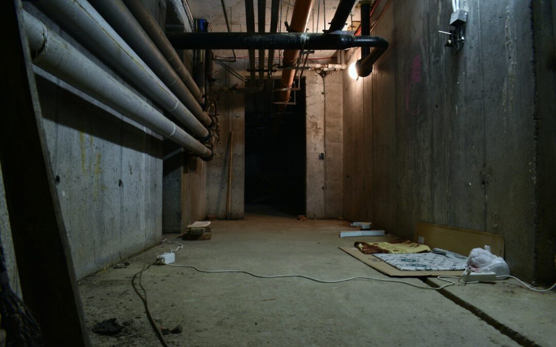 a dark room with pipes and a sheet of paper on the floor